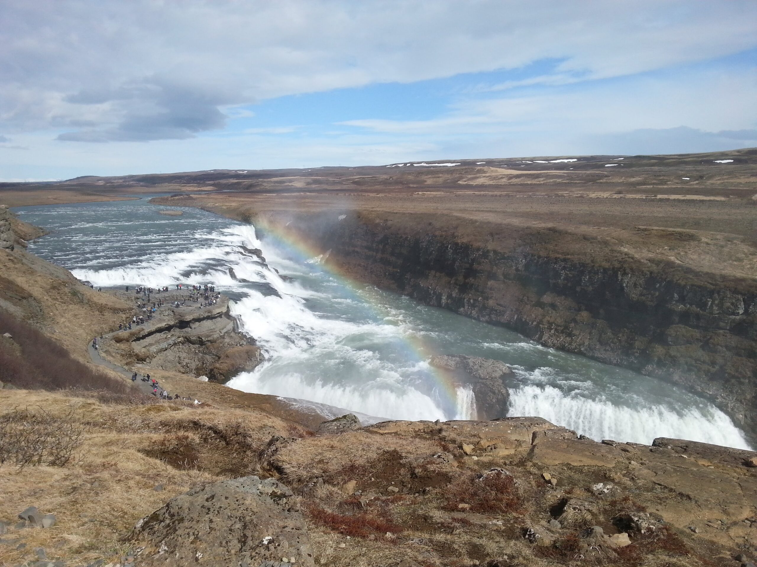 a rainbow over waterfall at Iceland